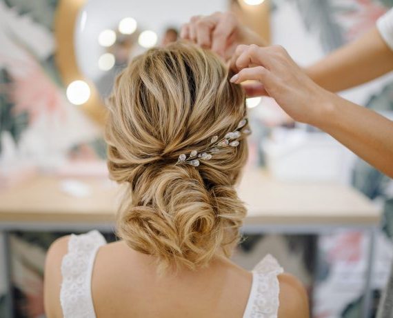 Hairdresser woman weaving braid hair, wedding styling.